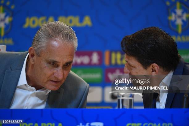 Brazil's national football team coach Tite listens to team director Juninho Paulista during a press conference to announce the list of players for...