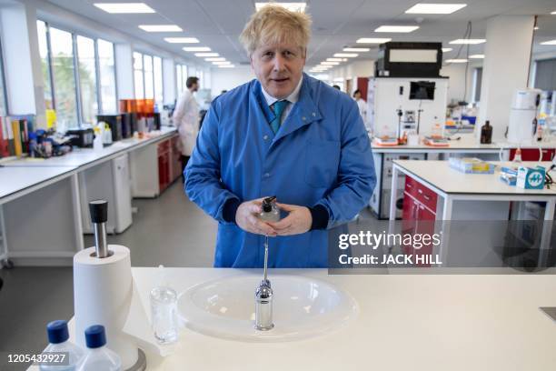 Britain's Prime Minister Boris Johnson gestures during a visit to the Mologic Laboratory in the Bedford technology Park, north of London on March 6,...