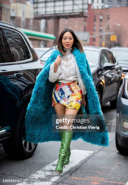Aimee Song is seen wearing multi colored skirt with print, blue coat, white knit, green boots outside Zimmermann during New York Fashion Week Fall /...