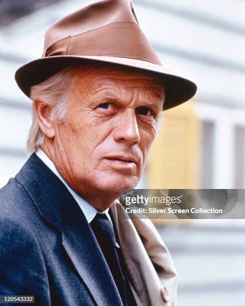 Richard Widmark , US actor, wearing a brown fedora, with a brown band, and a dark blue jacket, circa 1985.