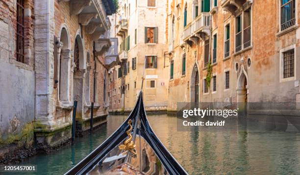 pov from a gondola on a canal in venice, italy - venice gondola stock pictures, royalty-free photos & images