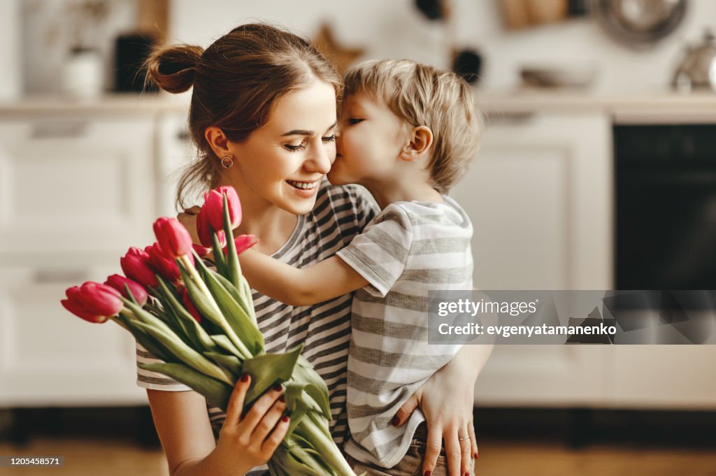 Happy mother's day! child son gives flowers for mother on holiday