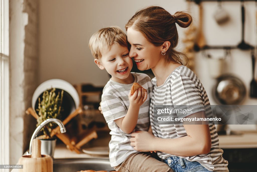 Preparation of family breakfast. mother and child son cut bread and eat cookies with milk in morning
