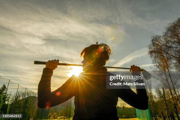 golfer leaning her golf club on her shoulders and with sunbeam - golf club stock pictures, royalty-free photos & images