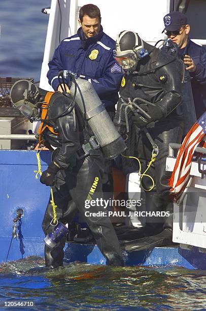 New York Police Department scuba team members jump into Jamica Bay from a NYPD boat 13 November 2001 to search for the missing flight data recorder...