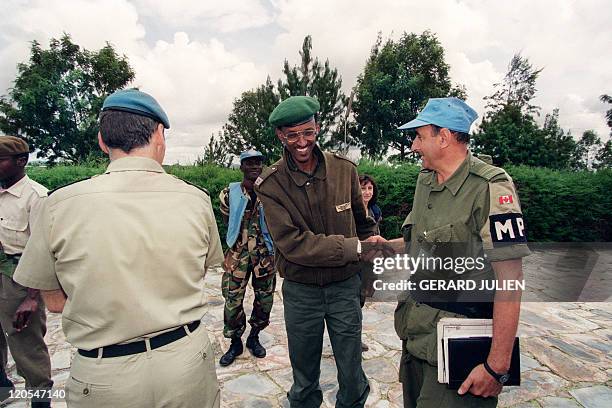 Picture taken 11 May 1994 in Buymba of Paul Kagame, leader of the Tutsi-led RPF shaking hands with an unidentified Canadian UN officer. After a week...