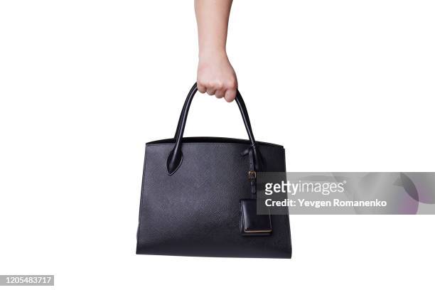 black leather handbag in women's hand on white background - black purse fotografías e imágenes de stock