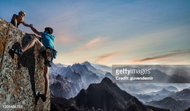 het paar helpende hand van het teamwerk - team climbing up to mountain top stockfoto's en -beelden