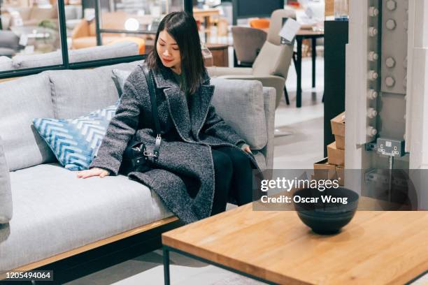 young woman at furniture store choosing sofa - furniture ストックフォトと画像