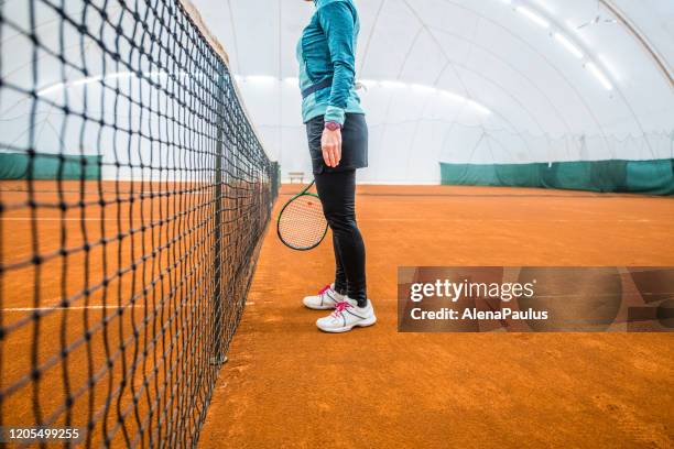 femme jouant le tennis dans le court de tennis intérieur se ferment vers le haut - tennis raquet close up photos et images de collection