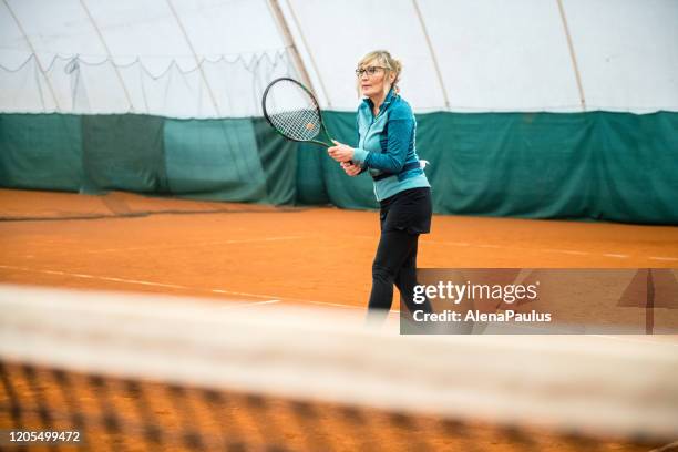 senior woman playing tennis - showus sport stock pictures, royalty-free photos & images