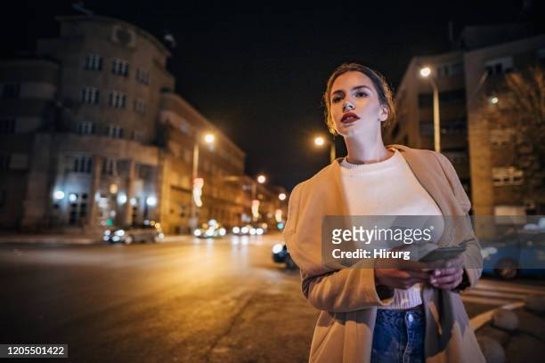 ein junges teenager-mädchen in der stadt fangen taxi taxi - calling a cab stock-fotos und bilder