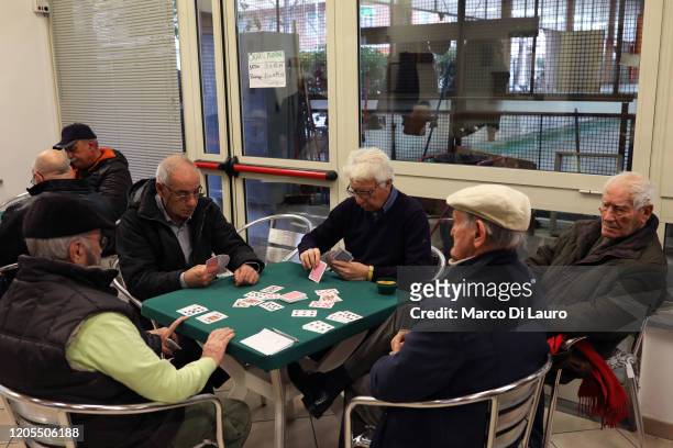 Seniors play cards in the bowling club of the Pigneto district non March 6, 2020 in Rome, Italy. The average age of Italian patients who have died in...