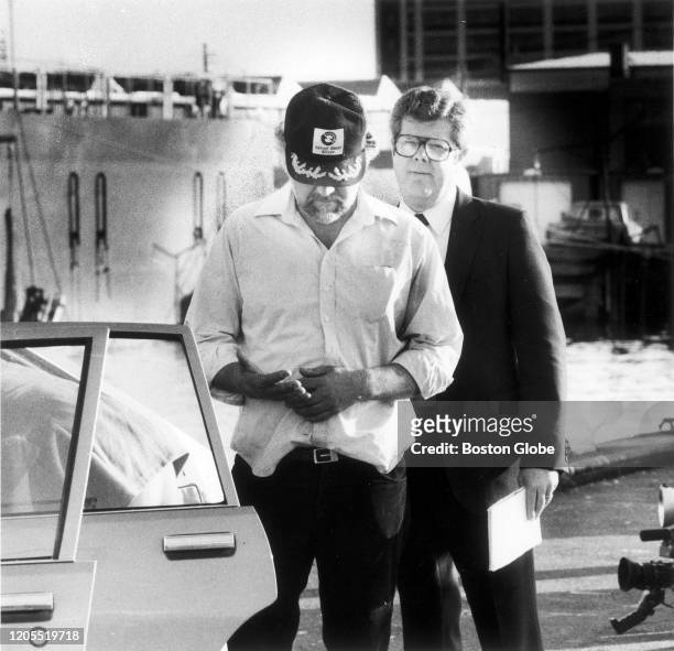 Customs agent leads Robert Andersen, captain of the Valhalla, away from the boat after it was seized at Pier 7 on the Boston Harbor on Oct. 16, 1984....