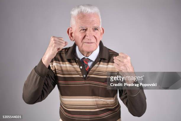 healthy , happy senior man punching on studio background - human body part stock-fotos und bilder