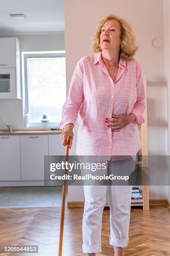 Senior woman on a rehabilitation after surgery or on recovery walks with walking cane at the  home. Rehabilitation and healthcare concept.