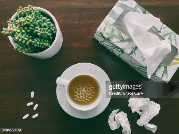 high angle view of tea, tissue, pills and plant on wood background - cup of tea from above stock pictures, royalty-free photos & images