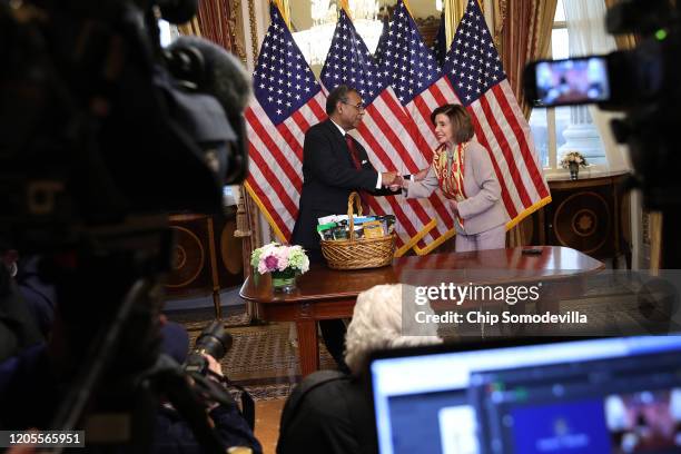 Speaker of the House Nancy Pelosi presents Rep. Emanuel Cleaver with a basket with items from the San Francisco area, including Ghirardelli...