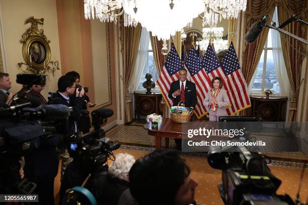 Journalists look on as Speaker of the House Nancy Pelosi presents Rep. Emanuel Cleaver with a basket with items from the San Francisco area,...