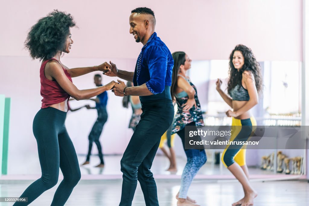 Danseurs de couples pratiquant dans le studio, retenant des mains