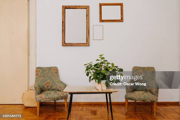 living room with coffee table and sofa chairs - table retro stockfoto's en -beelden