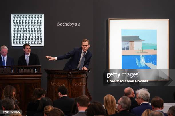 Auctioneer Oliver Barker brought the hammer down on David Hockney’s landmark pool painting ‘The Splash’, which achieved £23.1 million / $29.8 million...