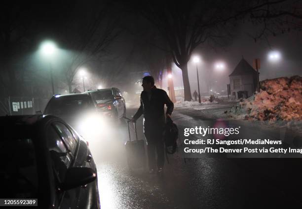 Democratic presidential candidate Michael Bennet pulls his suitcase to his car, before heading back to the hotel for the night, after speaking to...