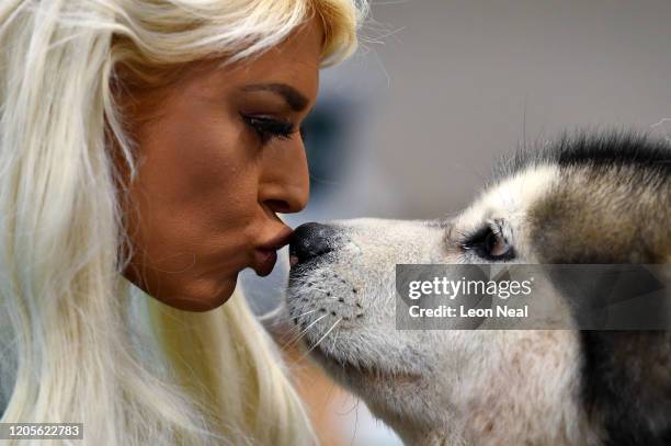 Woman kisses an Alaskan Malamute named 'Arctictreks Black Sheep' during grooming on day 3 of the Crufts dog show at the NEC Arena on March 7, 2020 in...