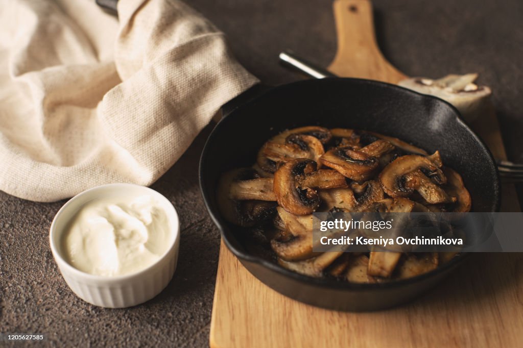 Fried Mushrooms in a vintage pan with fresh herbs