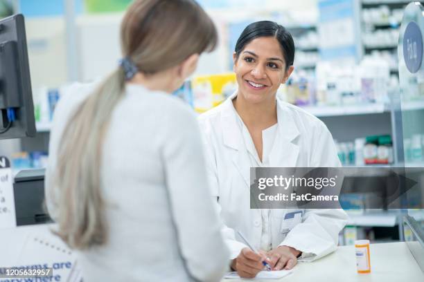 pharmacist giving patient instructions stock photo - pharmacist stock pictures, royalty-free photos & images