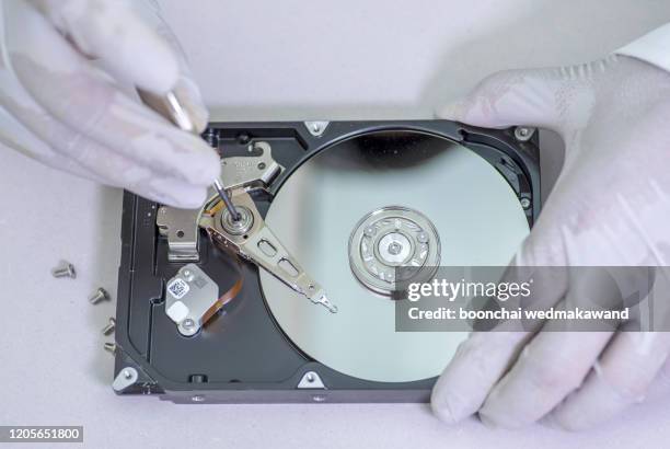 a technician repairing an hard disk with a tester - festplatte stock-fotos und bilder