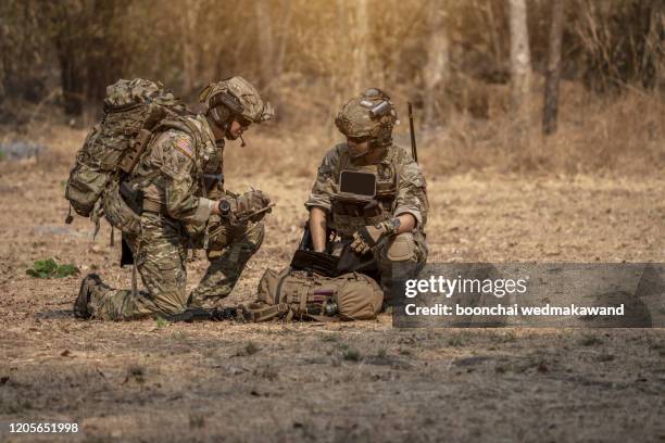 soldiers in special forces, army soldier in protective combat uniform holding special operations forces combat assault rifle. - campo di battaglia foto e immagini stock