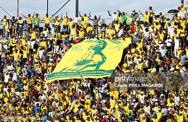 Mamelodi Sundowns fans hold a banner reflecting the face of their head coach Pitso Mosimane during the CAF Champions League Quarter-final second leg...