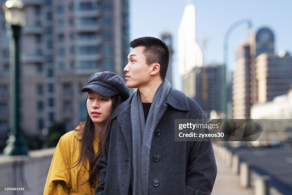 A young couple walks through the streets of Shanghai,China - East Asia,