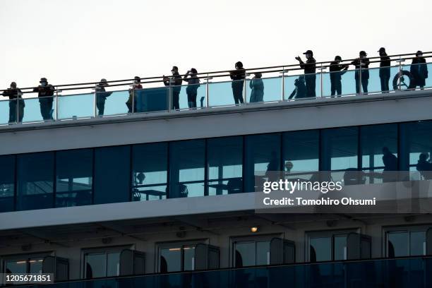 Passengers are seen on board the Diamond Princess cruise ship docked at Daikoku Pier on February 12, 2020 in Yokohama, Japan. The cruise ship, while...