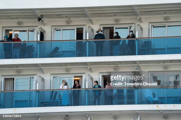 Passengers are seen on their balconies of the Diamond Princess cruise ship docked at Daikoku Pier on February 12, 2020 in Yokohama, Japan. The cruise...