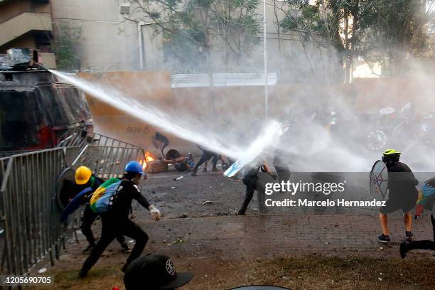 Riot police water cannon shoots water to demonstrators during a protest against the government of Sebastian Piñera on March 6, 2020 in Santiago,...