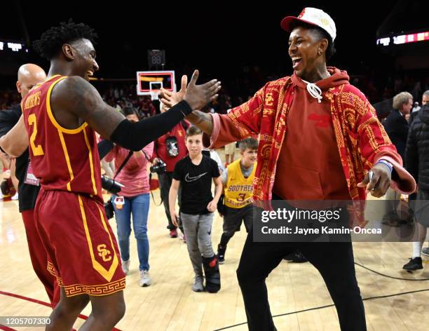 Former USC and NBA player Nick Young celebrates with Jonah Mathews of the USC Trojans after defeating the UCLA Bruins at Galen Center on March 7,...