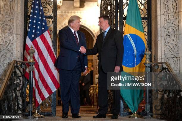 President Donald Trump shakes hands with Brazilian President Jair Bolsonaro during a diner at Mar-a-Lago in Palm Beach, Florida, on March 7, 2020.