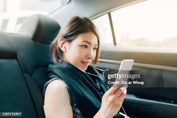 young woman having a conference call with smartphone on taxi - music from the motor city stock pictures, royalty-free photos & images