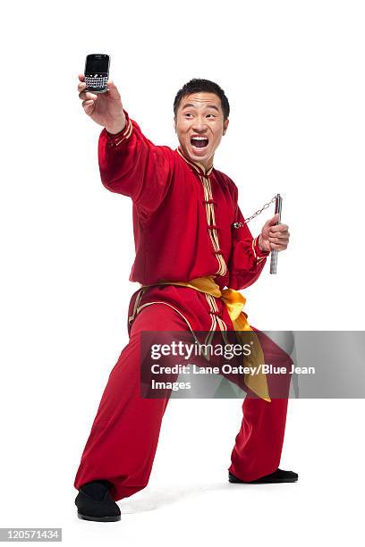 man in traditional chinese clothing doing martial arts - nunchucks stock pictures, royalty-free photos & images