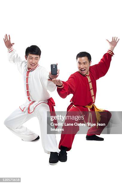 two friends looking at a mobile phone - kung fu pose stock pictures, royalty-free photos & images