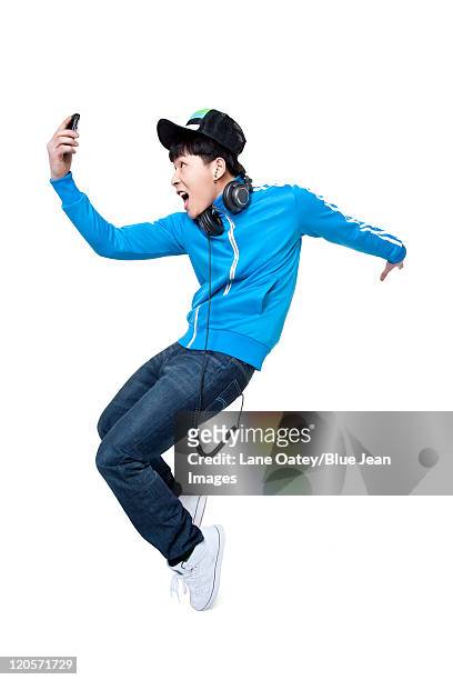man dancing while holding up his phone - homme mode studio photos et images de collection