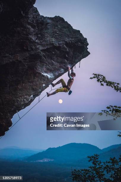 man climbing overhanging sport climbing route in new hampshire - overhangende rots stockfoto's en -beelden