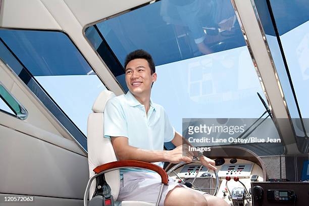 man in a yacht cockpit - captain yacht stockfoto's en -beelden