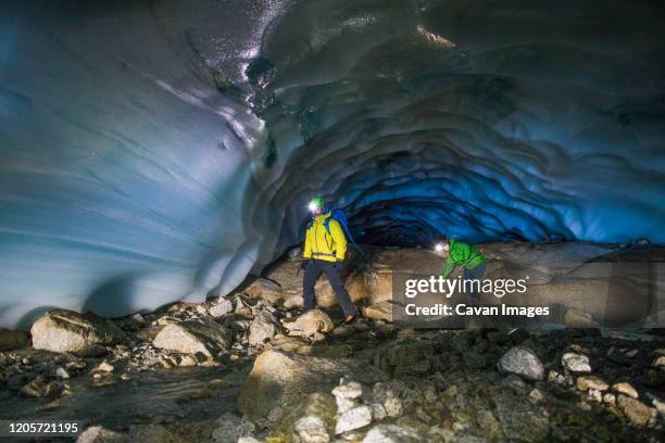 adventurous couple exploring ice cave near vancouver. - spelunking ストックフォトと画像