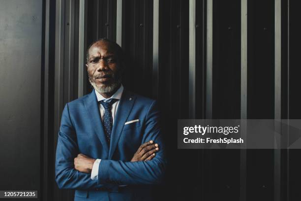 african businessman looking at camera - man in black suit stock pictures, royalty-free photos & images