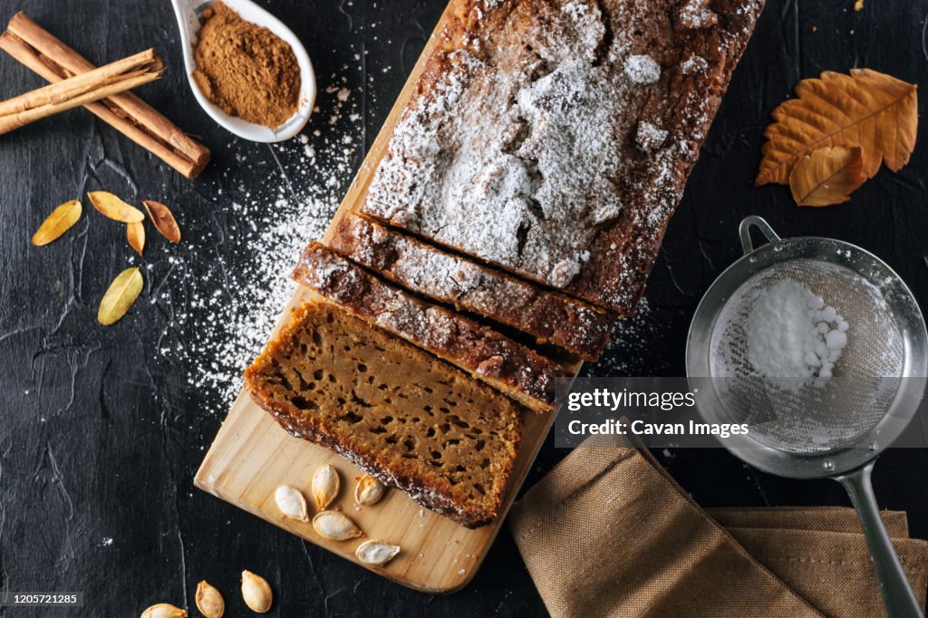 Pumpkin sponge cake cut into slices with powdered sugar on top