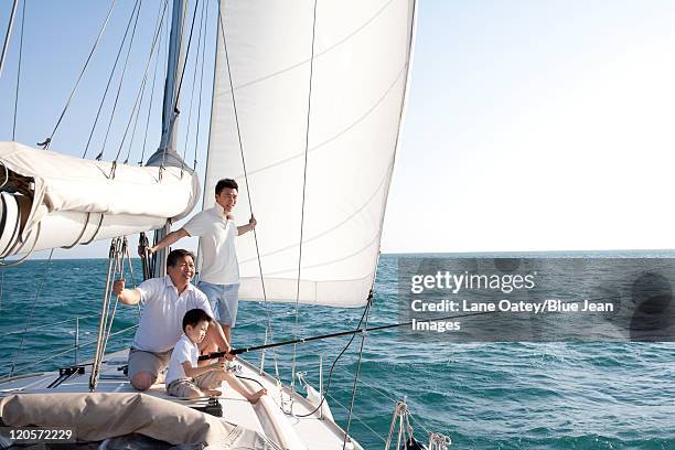 three generation of men fishing - father son sailing stock-fotos und bilder