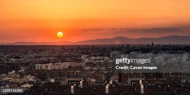 partial sun eclipse over madrid skyline on a warm summer sunset - twilight stock pictures, royalty-free photos & images